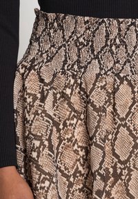 Ruskea ja kerma snake print -hame, jossa on rypytetty vyötärö, ominaisuuksina teksturoitu kuvio ja laskostettu muotoilu.
