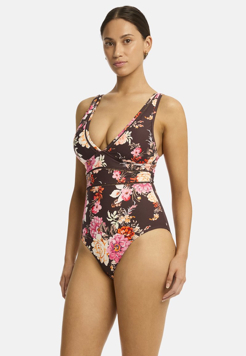 Effen badpak met een bloemenpatroon in tinten van roze en oranje op een donkerbruine achtergrond. Kenmerkt een diepe V-hals en brede banden.