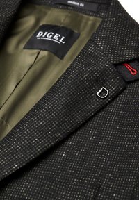 Schwarzer strukturierten Blazer mit dezenten hellen Mustern, olivgrüner Innenausstattung und silbernen Hardware-Akzenten. das Etikett trägt "DIGEL" mit modernem Schnitt.
