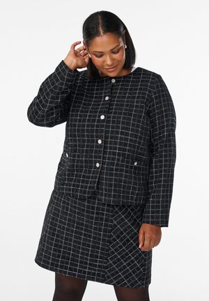 Black and white checkered jacket with matching skirt, featuring a round neckline, silver buttons, and textured fabric.
