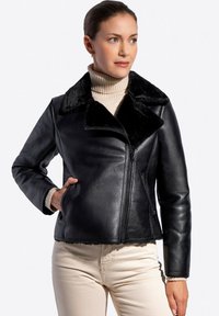 Czarna skórzana kurtka z kołnierzem z futra syntetycznego, zapinana na zamek błyskawiczny, posiada boczne kieszenie. Miękka tekstura, dopasowany krój i widoczne detale szwów.