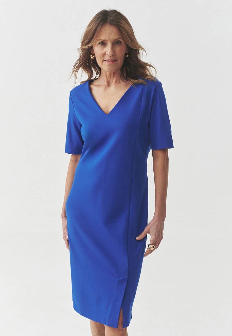 Blaues Kleid mit V-Ausschnitt, kurzen Ärmeln, geradem Schnitt und Seitenschlitzen. Die glatte Textur und das schlichte Design unterstreichen sein elegantes Aussehen.