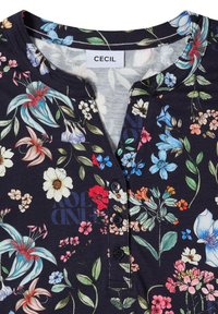 Blouse florale foncée avec des fleurs bleues, rouges, blanches et roses, patte de boutonnage, encolure ronde et étiquette "CECIL" au col.