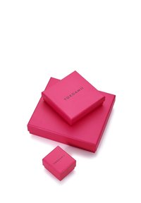 Trei cutii de cadou roz, amplasate una peste alta, cu o finisare netedă. Cea mai mare cutie este rectangulară, iar cutiile mai mici sunt pătrate, toate având imprimate "YOKOAMI".