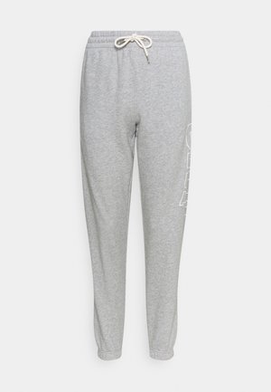 Pantalons de survêtement gris avec une taille à cordon, présentant une texture douce et une coupe fuselée. Un grand graphique blanc est imprimé sur le côté.