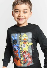 Black long-sleeve t-shirt featuring "Five Nights at Freddy's" characters in vibrant colors. Graphics include Freddy, Bonnie, Chica, and Foxy.