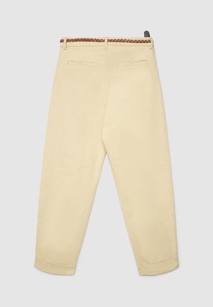 Pantalon beige avec une ceinture tressée marron, présentant deux poches arrière et une coupe fuselée. Tissu lisse et ourlets roulés.