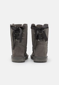 Bottes en daim gris avec une doublure douce en fourrure, dotées de lacets en ruban noir et d'une semelle en caoutchouc robuste. Design haut avec un bout arrondi.