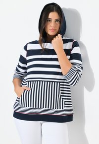 Sweat à capuche rayé en bleu marine et blanc, avec une poche kangourou, des poignets côtelés et un ourlet texturé avec des coutures rouges contrastées.