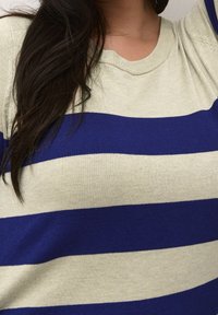 Pull à col rond avec rayures horizontales vertes et bleu marine ; texture douce ; tissu en maille ; coupe décontractée ; détails de coutures visibles aux épaules.