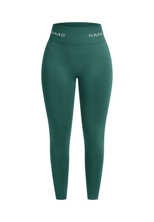 Groene leggings met een hoge tailleband en een witte "SMIL"-logo. Gladde textuur en een aangesloten vorm, ontworpen voor comfort en flexibiliteit.