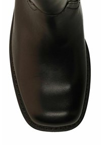 Zwarte leren laars met een ronde vierkante neus en zichtbare stiksels langs de rand van de zool.