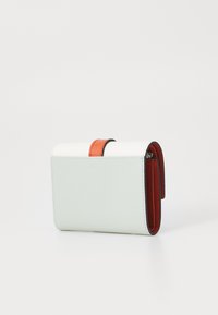 Compact portemonnee van lichtgroen leer met een rode accentriem. Kenmerkt zich door een gladde textuur en een gevouwen ontwerp met zichtbare stiksels.