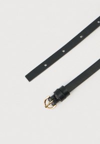 Μαύρη ζώνη από δερματίνη με υφή και χρυσή μεταλλική πόρπη· διαθέτει πολλαπλές εγκοπές για ρύθμιση μεγέθους και λεία επιφάνεια.