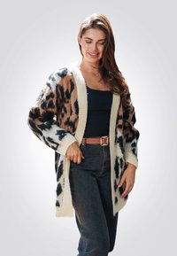 Gebreide cardigan in een bruin en zwart luipaardpatroon met crèmekleurige afwerking. Losse fitting, lange mouwen, open voorkant en een gestructureerde stof.