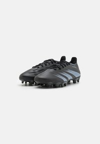 Zwarte voetbal schoenen met een gestructureerde bovenkant, drie lichtblauwe strepen en een stevige rubberen zool met noppen voor grip en tractie.