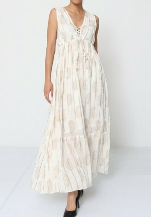 Robe maxi en tissu crème clair avec un devant à lacets, un ourlet à volants et des accents de motif en feuilles d'or ; design sans manches avec une coupe décontractée.