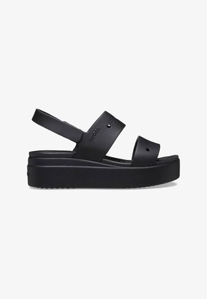 Sandale plateforme noire avec deux larges brides et une bride arrière, avec de petits trous de ventilation et le logo Crocs sur la bride latérale.