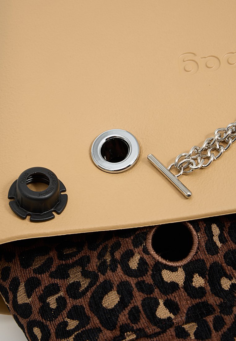 Torebka z sztucznej skóry w kolorze tan, z srebrnym łańcuchem, czarnym oczkiem i wnętrzem w panterkę widocznym przez otwór.