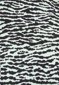 Patterned fabric featuring a black and mint green abstract design, resembling animal print, with smooth texture and varying wave-like shapes.