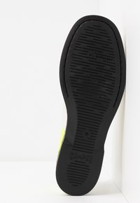 Semelle d'une chaussure noire avec un motif de grip texturé, étiquetée "CAMPER" et taille "39", sur fond blanc.