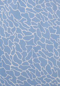 Blått tyg med ett abstrakt vitt mönster av vågiga, oregelbundna linjer på en slät textur som skapar en flytande design.