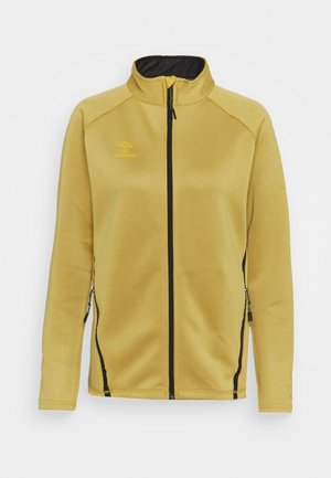 Giacca in pile gialla con colletto alto. Caratterizzata da una cerniera nera e tasche laterali, con dettagli in cuciture nere e logo sul petto.