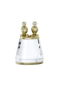 Figurina di cristallo con base in accento dorato. Presenta due figure che si abbracciano, sormontate da un cristallo rotondo e uno a forma di stella. Superfici trasparenti e riflettenti.