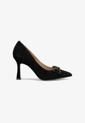 Black suede high-heeled pump with a pointed toe, featuring a decorative strap adorned with black accents and a slightly curved heel.