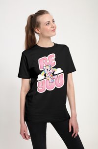 Sort t-shirt med et farverigt grafisk motiv af en bjørn, der holder et hjerte, med teksten "BE YOU" i pink ovenfor og skyer i baggrunden.