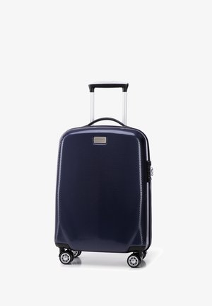 Valigia rigida navy con finitura texture, manico estensibile, quattro ruote e chiusura a zip. Presenta una piccola placca metallica con il marchio.