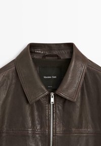 Dunkelbraune Lederjacke mit Kragen, silbernem Reißverschluss und schwarzem "Massimo Dutti" Etikett innen am Kragen.