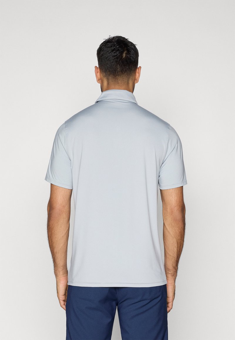 Hellgraues Poloshirt mit kurzen Ärmeln und Kragen, glatte Textur und lockere Passform. Getragen mit dunkelblauen Shorts, Rückansicht gezeigt.