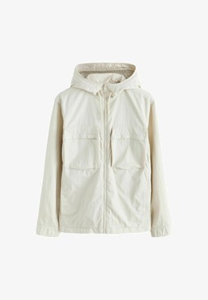 Svetlo béžová bunda na zips s kapucňou, ktorá má dva predné vrecká, textúrovanú látku a elastické manžety pre príjemné nosenie.