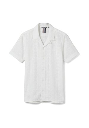 Chemise blanche à manches courtes avec rayures verticales texturées et col camp, posée à plat sur un fond blanc.