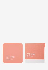 Peachfarget kompakt rouge med jevn finish og avrundede kanter. Har et minimalistisk design med hvit skrift på forsiden.