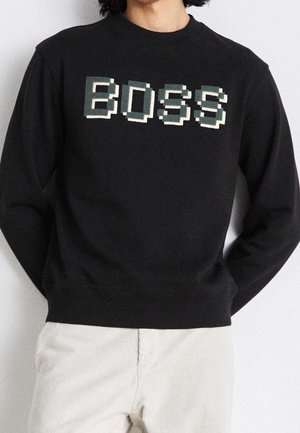 Schwarzer Sweatshirt aus weichem Stoff mit einem blockpixelierten "BOSS"-Design in Grün und Creme. Rundhalsausschnitt und gerippte Bündchen.
