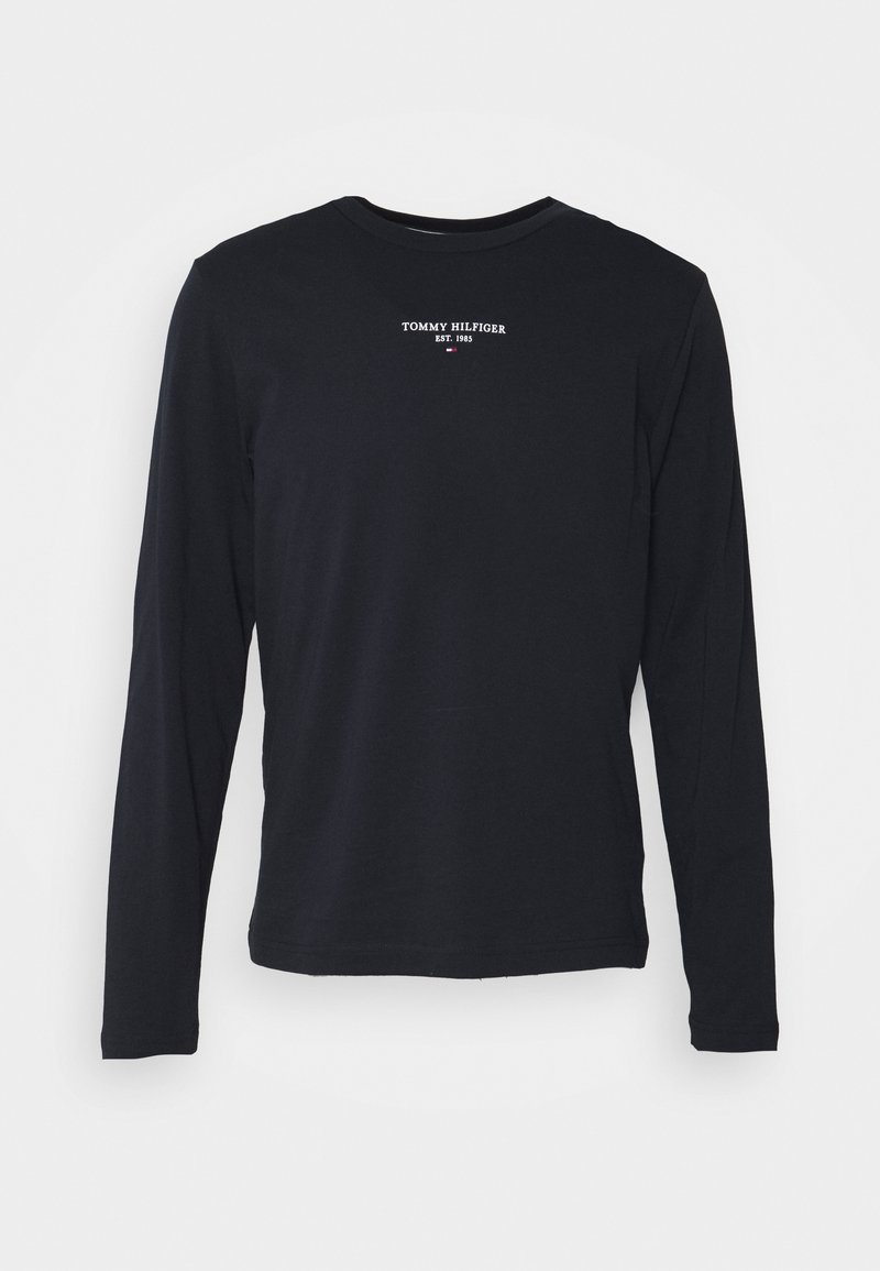 Černé tričko s dlouhým rukávem vyrobené z bavlny, s malým bílým logem "TOMMY HILFIGER EST. 1985" umístěným na středu hrudníku.