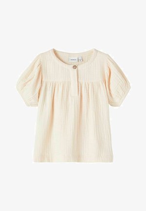 Top de algodón color melocotón claro con mangas cortas abullonadas, pliegues horizontales, escote redondo y cierre de botones en la parte delantera.