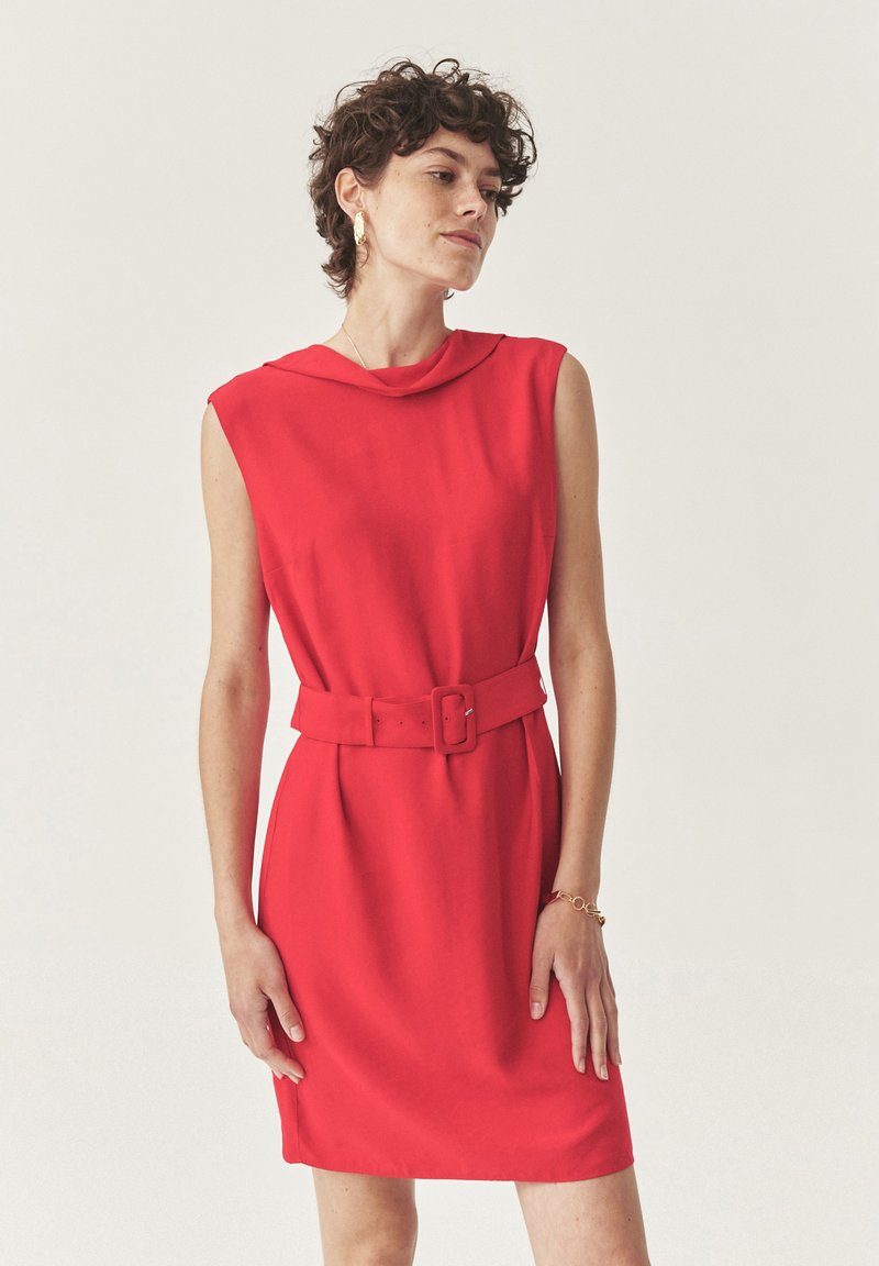 Rotes ärmelloses Kleid mit hohem Kragen und tailliertem Bund. Hergestellt aus einem glatten Stoff, mit einem lässigen Schnitt und subtilen Drapierungsdetails.