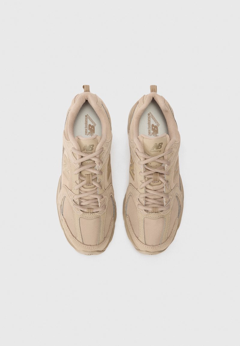 Beige Sportschuhe mit einem Obermaterial aus Mesh und Wildleder, ausgestattet mit einer gepolsterten Sohle, strukturierten Akzenten und tonalen Schnürsenkeln. Klassisches Design.