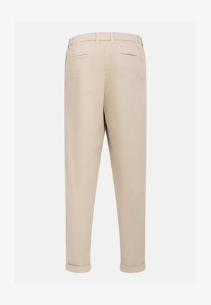 Beżowe spodnie o dopasowanym kroju, z tylnymi kieszeniami i podwiniętymi mankietami. Materiał jest gładki z delikatnym połyskiem, co nadaje im elegancki wygląd.