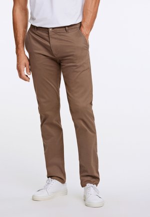 Brown cotton chinos with a straight fit, featuring side pockets and a button closure, paired with white sneakers. Smooth texture.