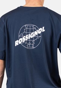 Námořnická modrá bavlněná tričko s bílou grafikou globu a textem "ROSSIGNOL" na zádech; krátké rukávy a design s kulatým výstřihem.
