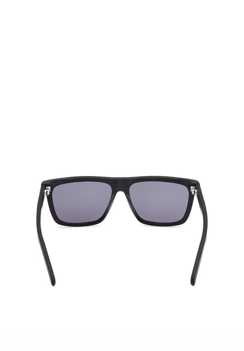 Gafas de sol rectangulares negras con lentes de color oscuro y varillas delgadas, vistas desde el frente sobre un fondo blanco.