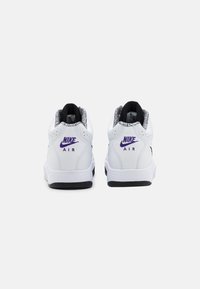 White Nike sneakers featuring a structured shape, black and purple accents, perforated details, and a textured inner lining.