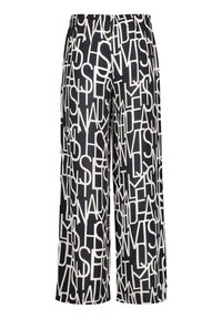 Černé kalhoty širokého střihu s bílými abstraktními překrývajícími se písmeny a elastickým pasem.