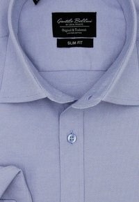 Lichtblauwe slim-fit dress shirt van gestructureerde stof, met een puntige kraag, een enkele knoopsluiting en een klein labeltag.