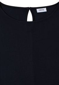 Encolure de vêtement noire avec une petite ouverture en forme de trou de serrure et une étiquette blanche portant le nom de la marque Cecil.