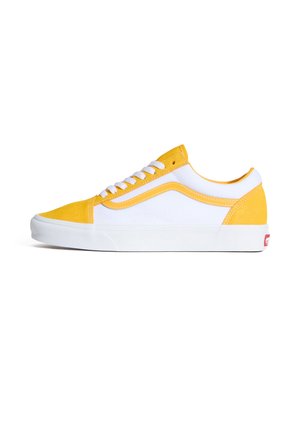 Gule og hvide lærreds-sneakers med en struktureret ruskindstip, glatte sider og hvid gummisål, med klassiske snørebånd og syninger.